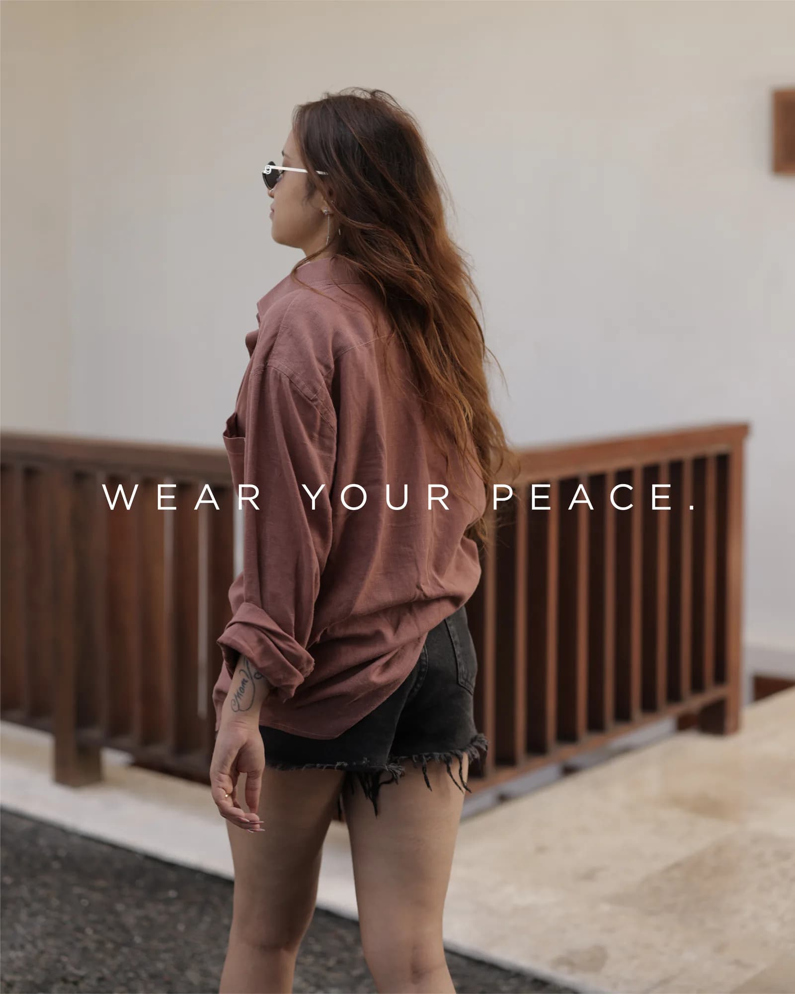 Campaign frame of a model in linen against a pale wall