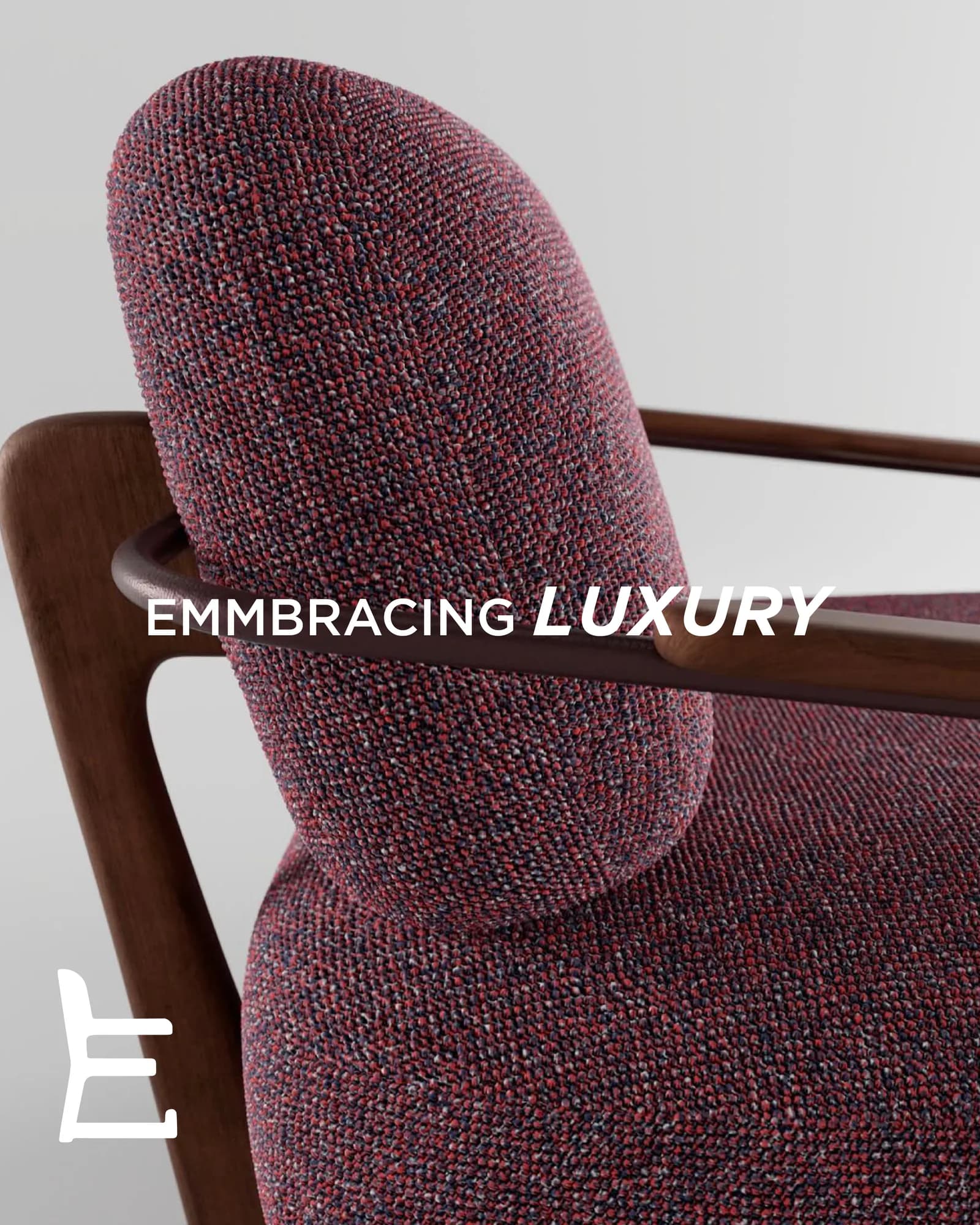 A plum armchair photographed against a pale studio ground